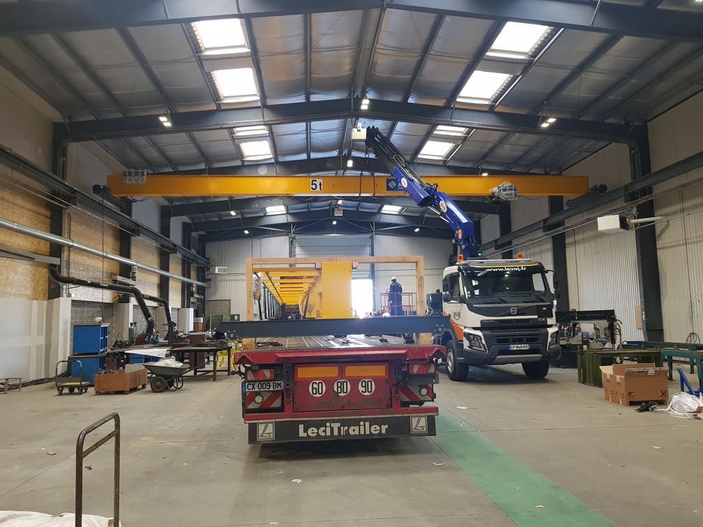 Camion grue dans un hall industriel, déchargement d'un pont roulant