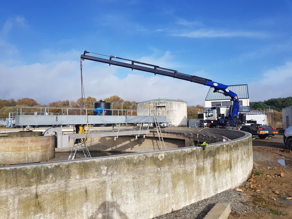 Volvo FMX grue repliée devant un site industriel