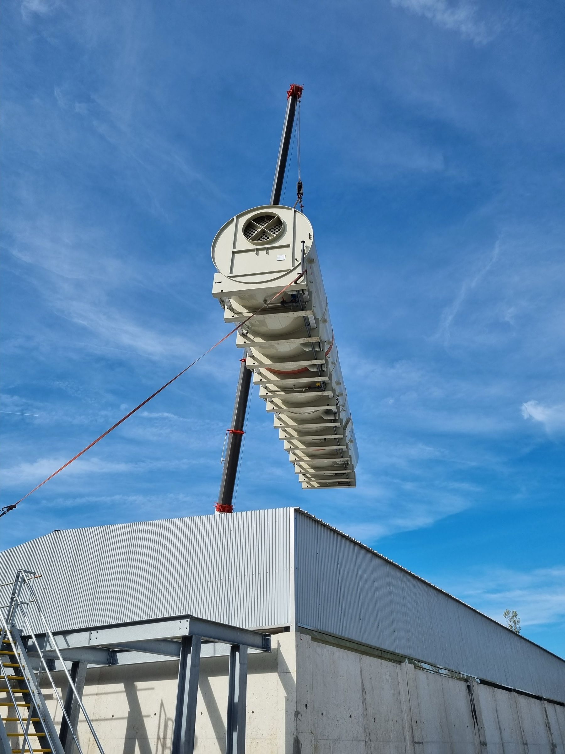 Levage d'un équipement de toiture au-dessus d'un bâtiment industriel