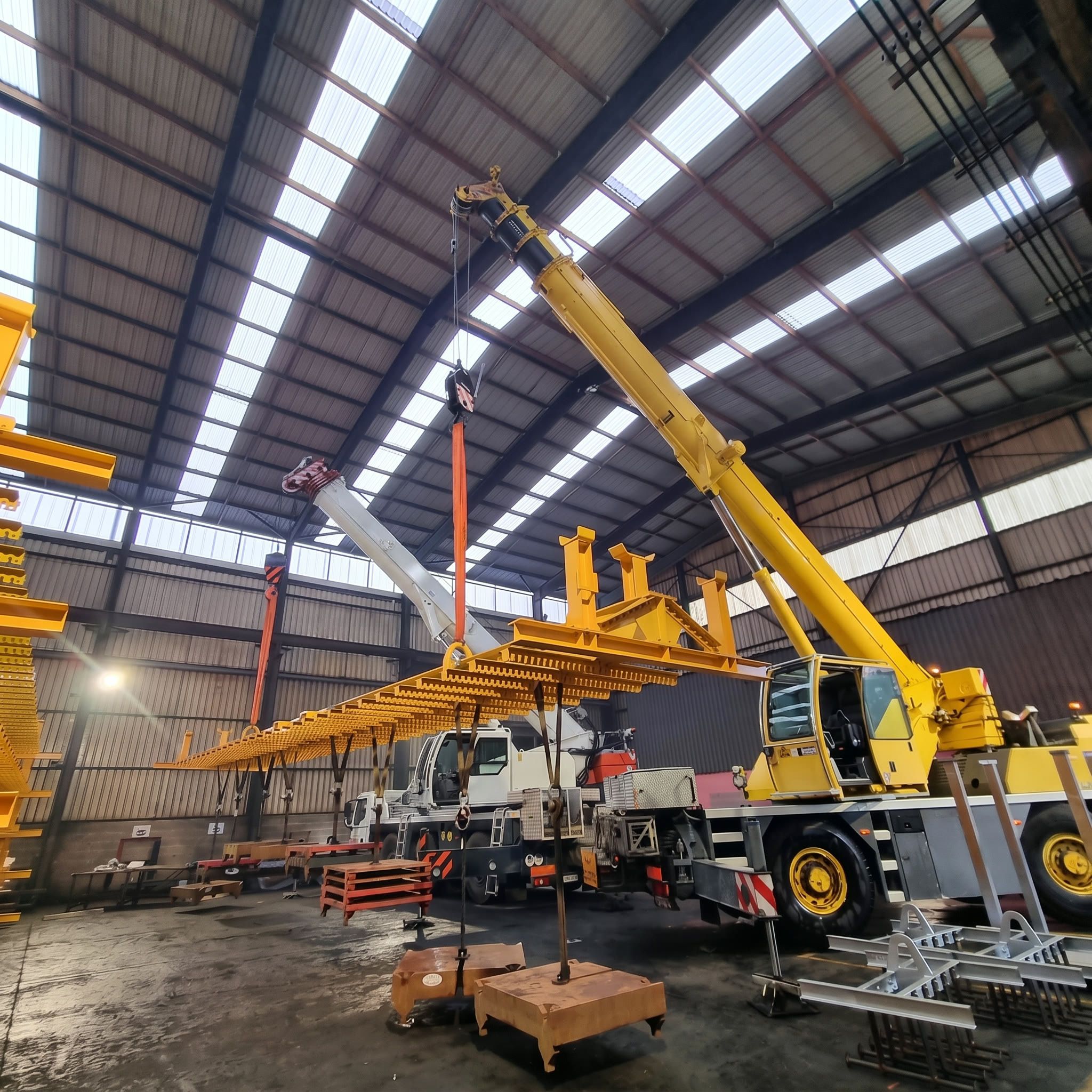 Manutention de structures métalliques dans un hall, à deux grues