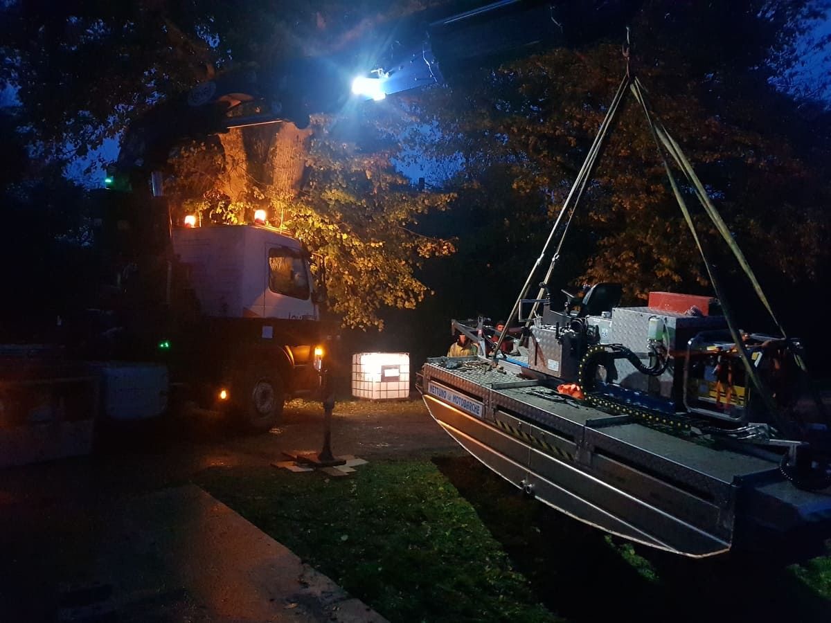 Levage de nuit d'une embarcation de travail sous un projecteur