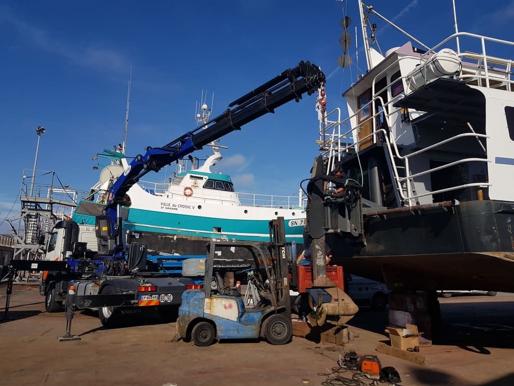 Manutention d'un chalutier sur un terre-plein portuaire