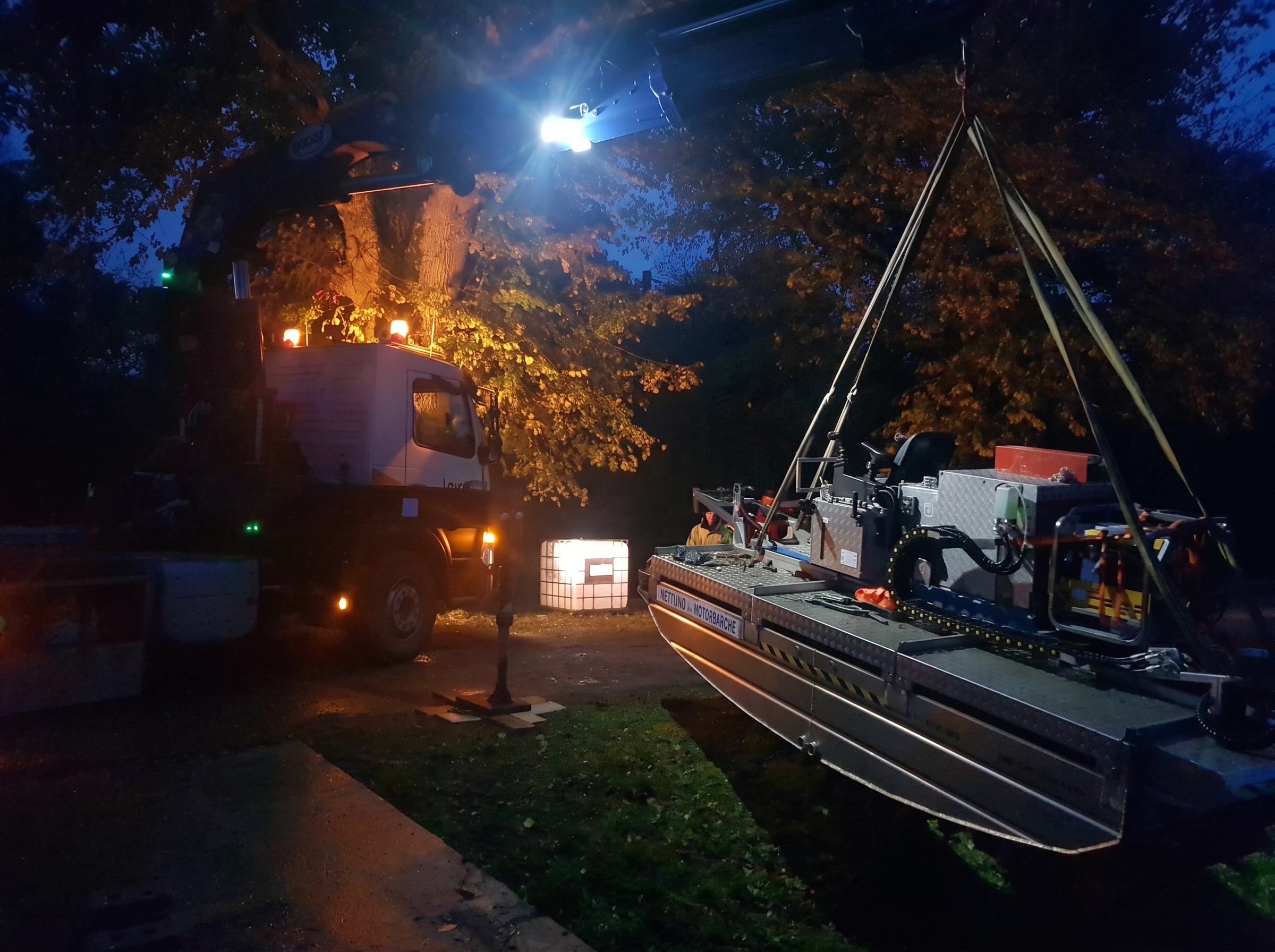 Levage de nuit d'une embarcation de travail sous un projecteur
