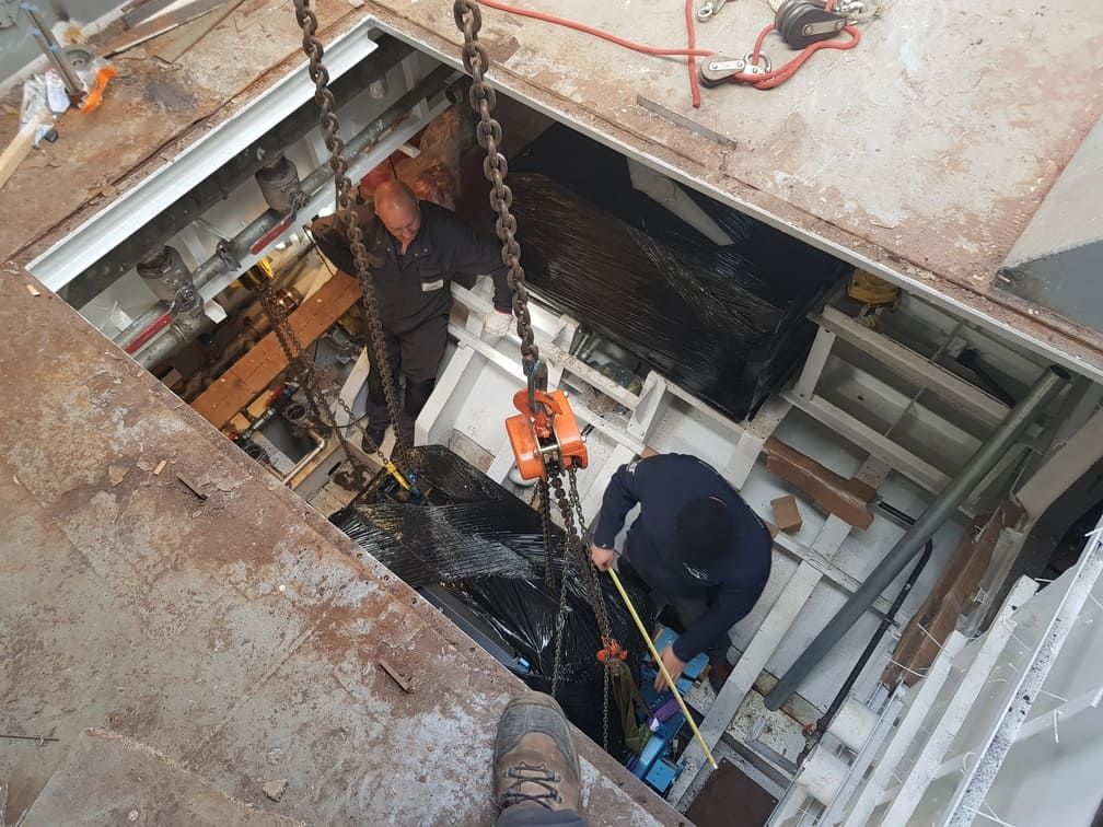 Descente d'un équipement par une trappe en sous-sol