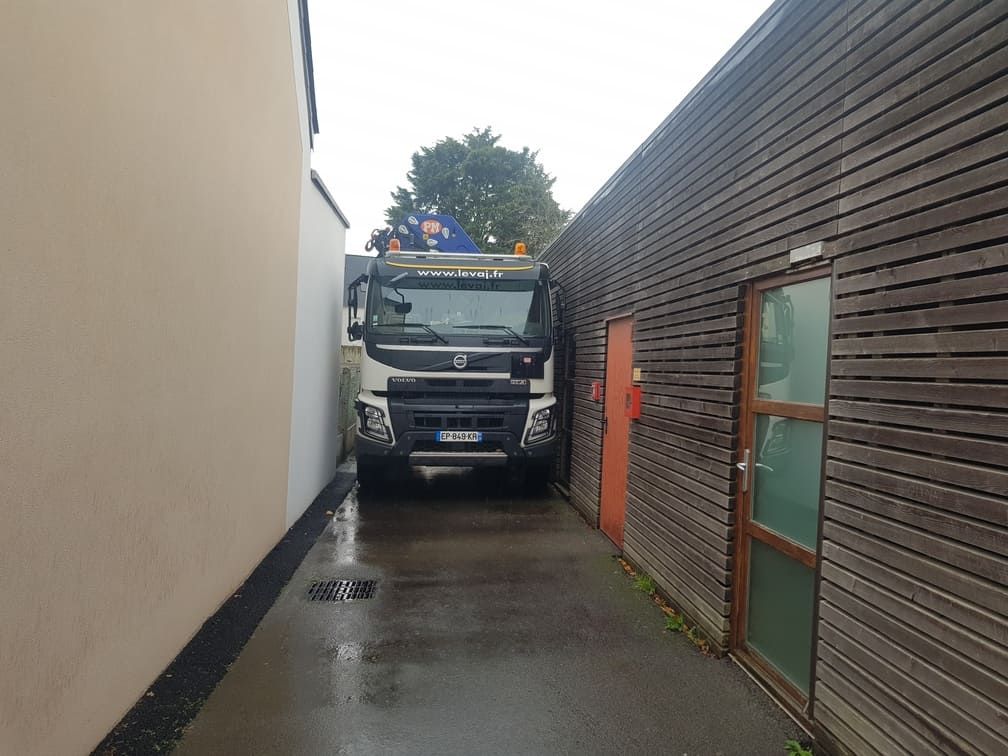 Camion grue engagé dans un passage étroit
