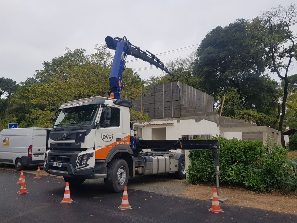Camion grue en position devant une maison en construction