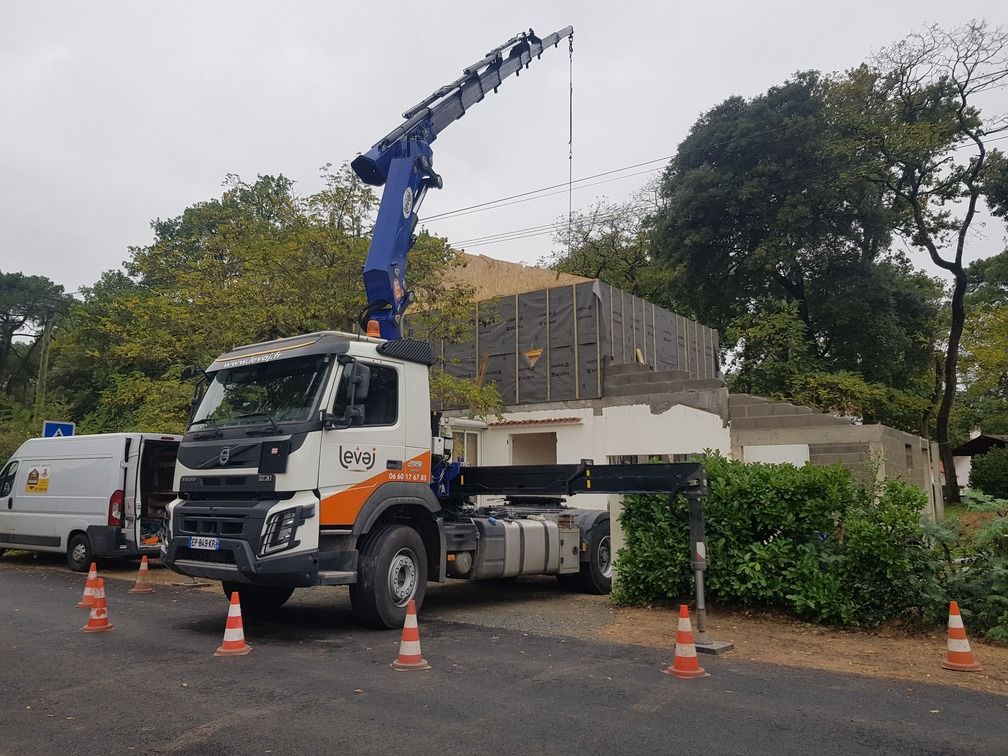 Grue dépliée au-dessus d'un chantier de maison bois
